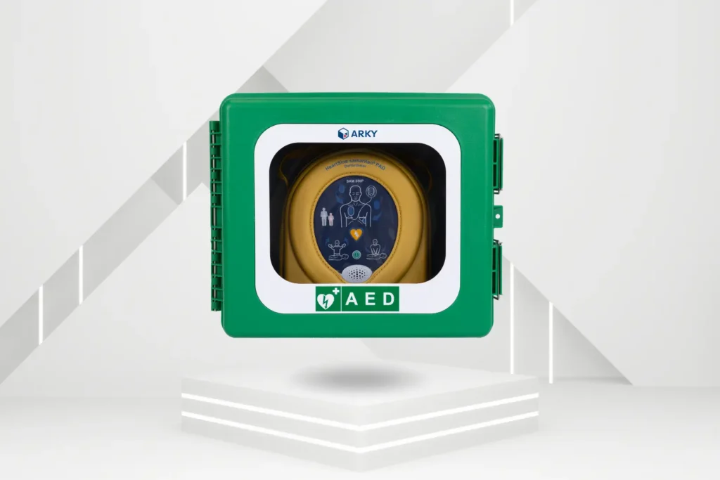 Grönt väggmonterat skåp från ARKY med genomskinlig front som innehåller en gul hjärtstartare, märkt med AED-symbol.